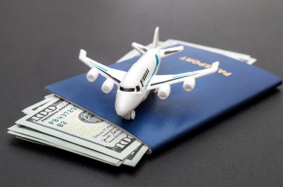 Airplane toy with passports and money on black background