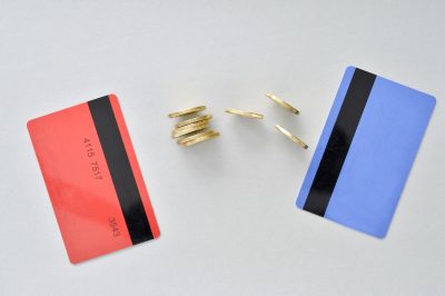 Red and blue bank cards with coins between - balance transfer concept