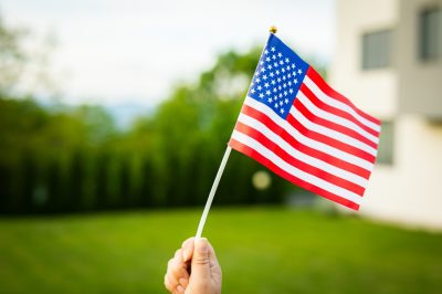 American flag waving on wind in backyard