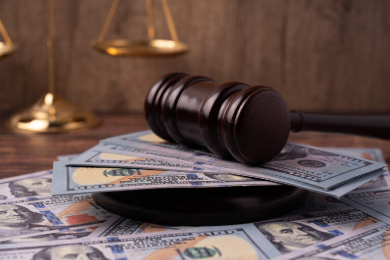 Gavel on top of American 100 dollars money and scale of justice