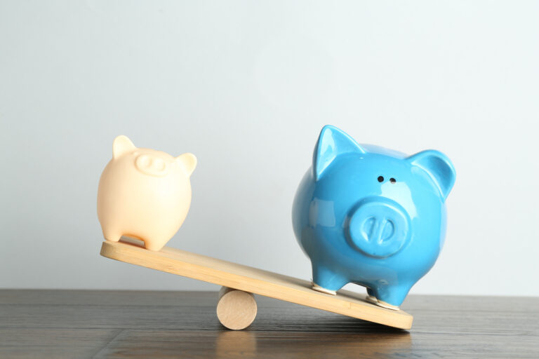 two piggy banks on scale, representing comparison between cash advance app and predatory payday loan