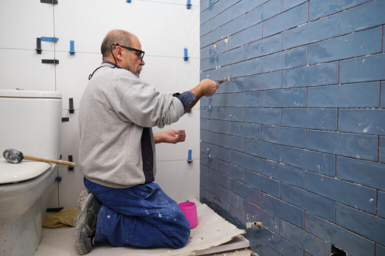 Tile worker doing tile work in bathroom remodel project