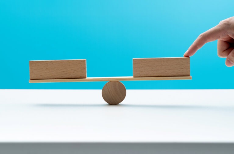 Blank blocks on wooden seesaw representing the two debt options