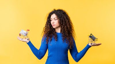 Woman standing in front of yellow background with 2 card options