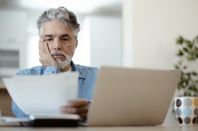 Man at computer reading options between debt relief and bankruptcy