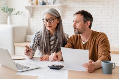 Gen X couple reviewing bills on a laptop