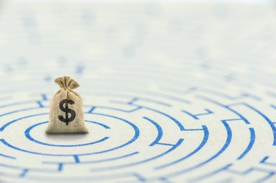 Money bag in middle of maze on paper