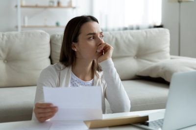 Frustrated young woman thinking of financial problems.