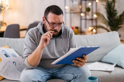 Man on couch looking at debt consolidation options