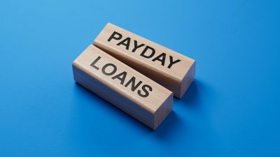 Payday loans written on wooden blocks with blue background