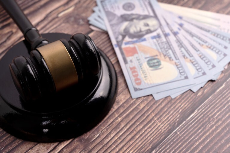 Close up of a gavel with bank notes.