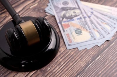 Close up of a gavel with bank notes.