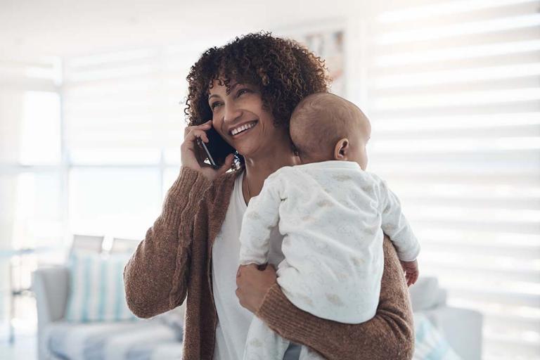 Smiling woman on phone with baby