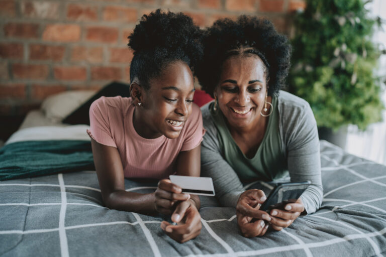 Mother and daughter shopping with credit card on smartphone