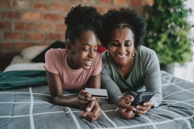 Mother and daughter shopping with credit card on smartphone