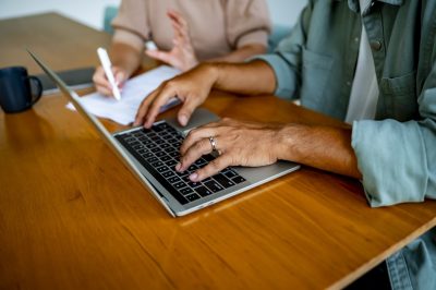 Man and woman sitting at table using laptop to apply for a credit card