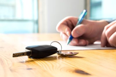 Woman signing financing documents for new car
