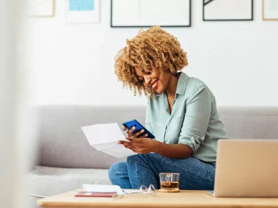 Woman happy with phone and paper
