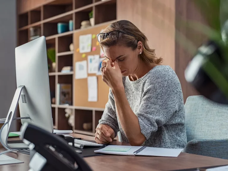 Woman at desk looking stressed